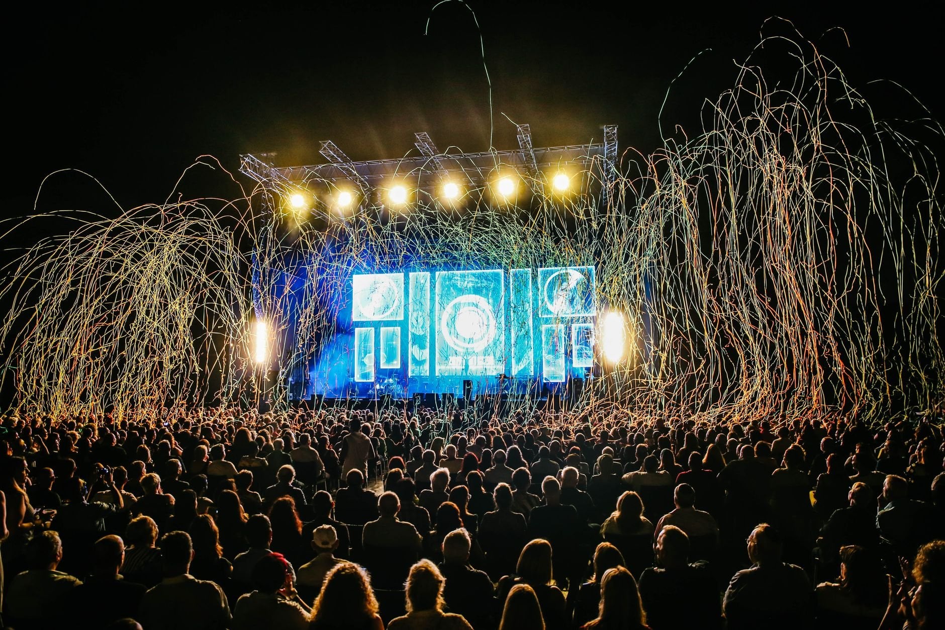 Dynamic live music concert with vibrant stage lights and a lively crowd enjoying the night.